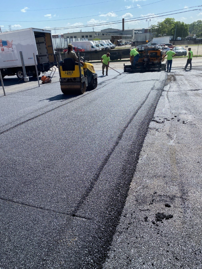 team of workers paving asphalt on machines